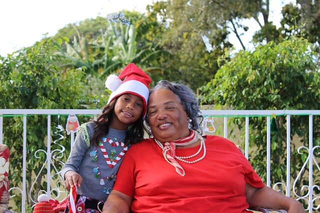 A grandma and granddaughter pose for a holiday picture.