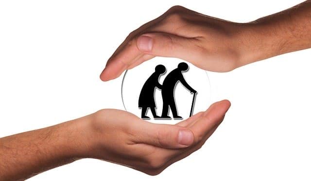 A hand covers two elderly people silhouettes