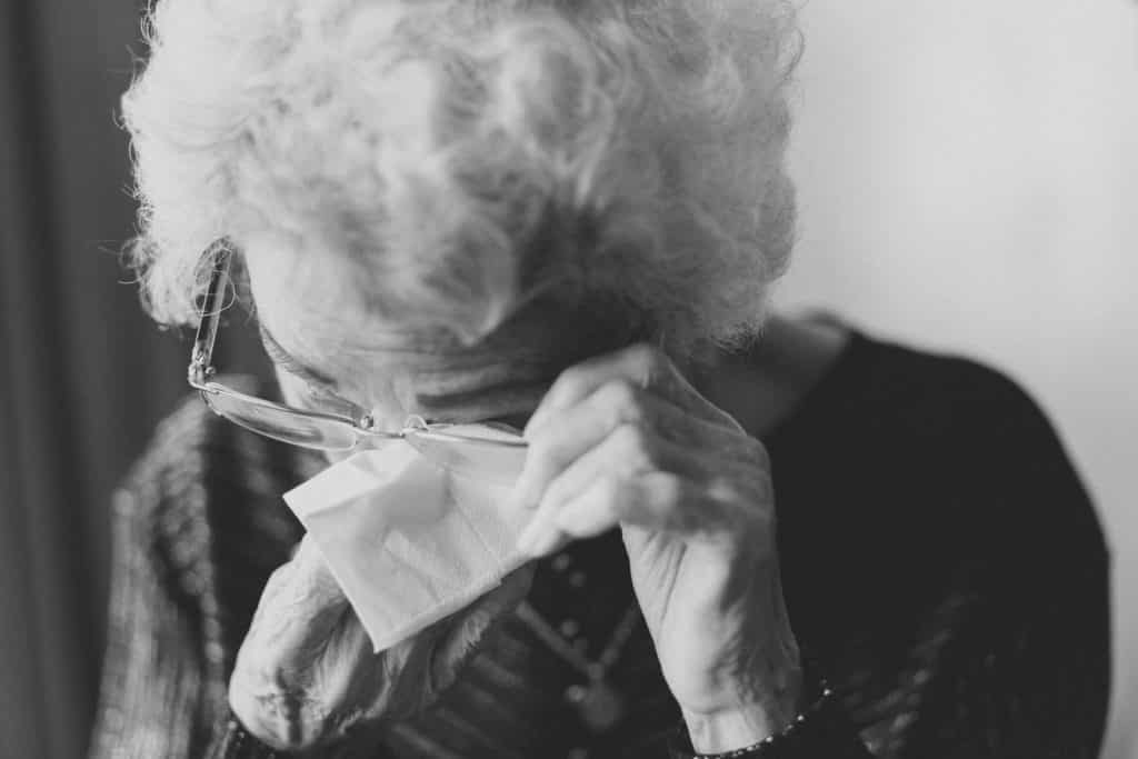 An elderly woman is crying